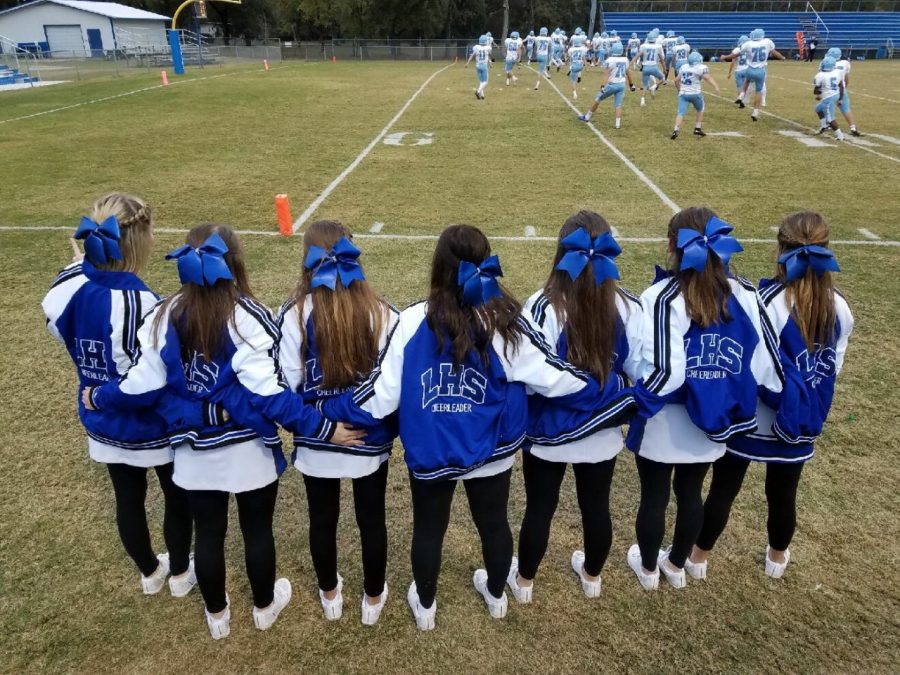 JV cheerleaders stand together on the sidelines during their final home football game of the 2018 season.  The cheerleaders are now preparing for the 2019 season. 