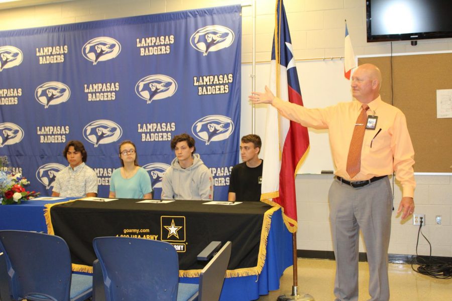Principal Joey McQueen introduces newly enlisted seniors Dylan Kannan, Elysse Butler, Kevin Wylie and Kyle Johnson at the Military Recruitment Ceremony on May  16. 
