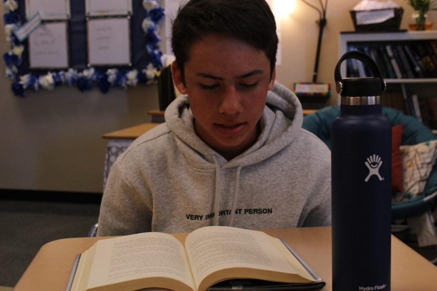 Freshman+Samuel+Zmolik+reads+with+his+Hydro-flask+on+his+desk+during+academic+period.+