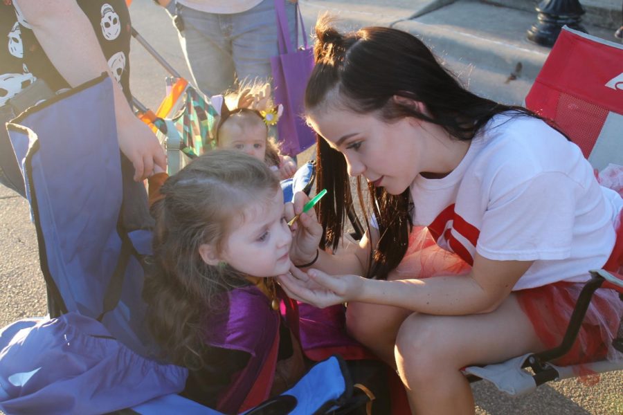 Flames social leader vice president Christina Dobbertin paints a childs face during Squared Silly on Oct. 26. 