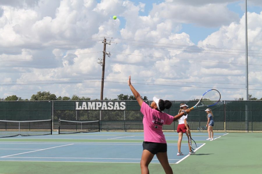 Freshman+Hannah+Durbin+serves+the+ball+during+tennis+practice.