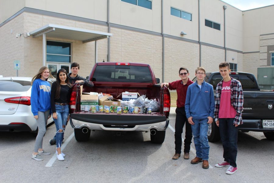 Student Council members with items collected from the annual food drive competition to support the Lampasas Mission.