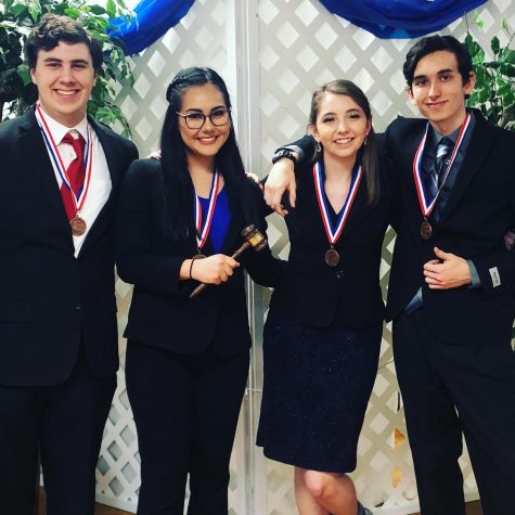 Junior Cole Wheeler, junior Janice Hanson, senior Mallory Fitzner, and junior Jacdon Green celebrate placing at the district meet. Hanson also won top speaker. 