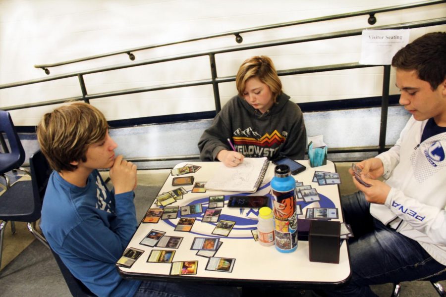 Freshman Brad Roberts, sophomore Shyla Roberts and sophomore Anthony Pena play Magic The Gathering during lunch Feb. 5. They will participate in the tournament in the library Feb. 12. 
