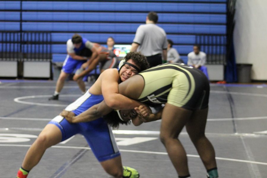 Junior Anthony Harris goes for a takedown during one of his finals matches leading him to get 4th and qualifying for the regional meet. 