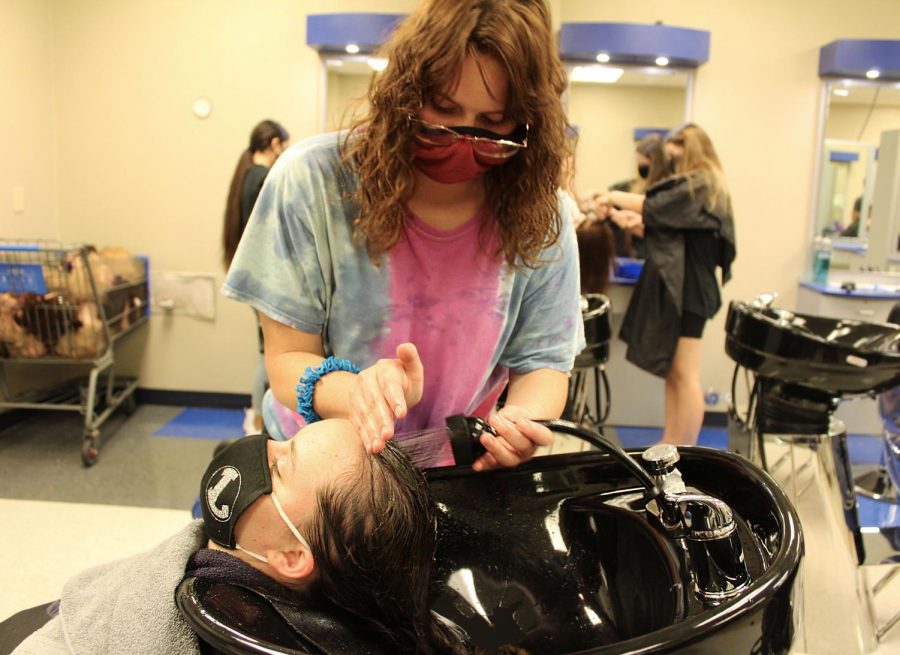 Senior Jalena Rostad washes another students hair during advanced cosmetology class. 