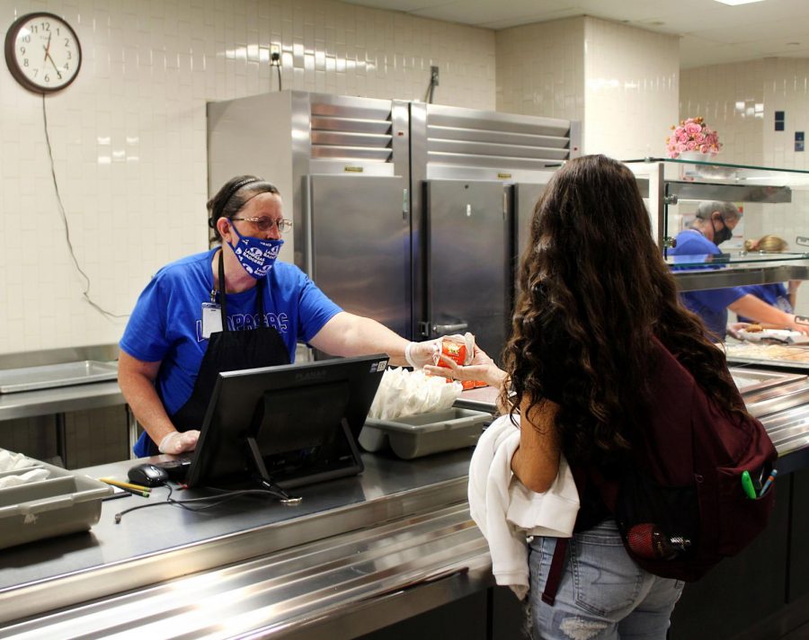 Cafeteria employee Donna Dyer gives a student juice to go with her lunch Sept. 25. Breakfast and lunch are free to all secondary students through the Fall Free Meals program until funds from the USDA are exhausted.