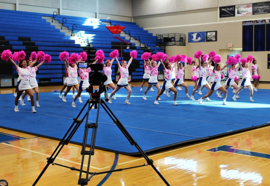 The+cheerleaders+perform+in+front+of+the+camera+for+the+virtual+Pink+Out+pep+rally.+Students+watched+this+pep+rally+during+academic+period+Oct.+23.+