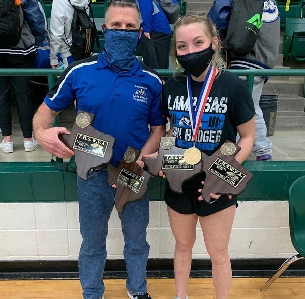 Girls powerlifting coach Duane Young and senior Alyssa Ayers hold Ayers awards from the State Powerlifting meet March 19.