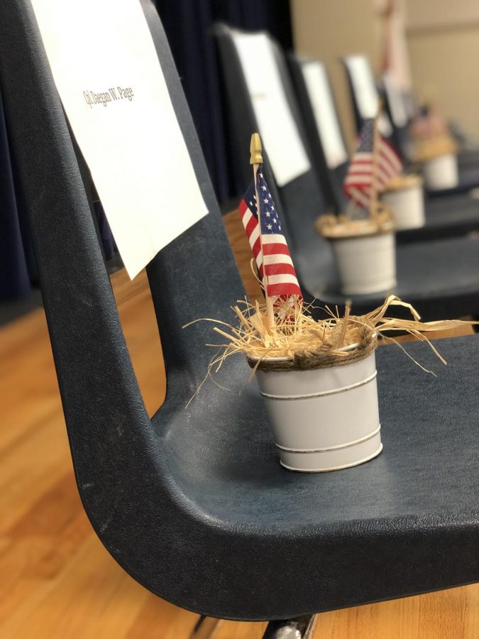 Thirteen chairs with American flags sit on the stage in the cafeteria to honor the soldiers who died in the bombing at the Kabul airport. 