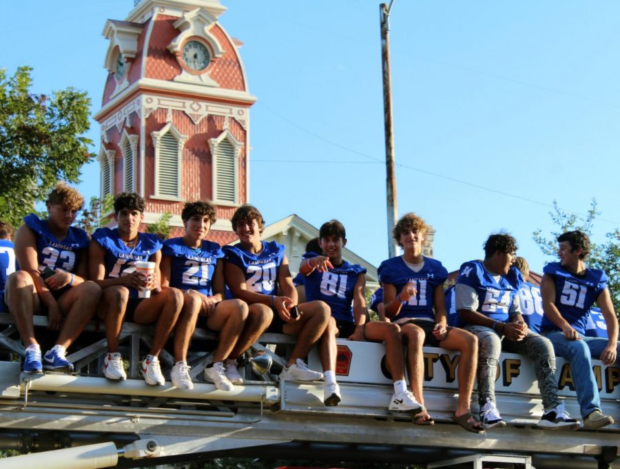 Varsity football players ride a fire truck in the homecoming parade Sept. 15. 