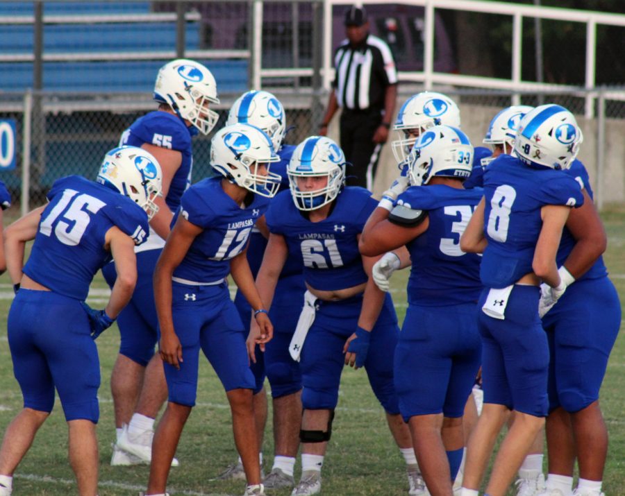 Varsity football players huddle between plays during the game on Sept. 17. 