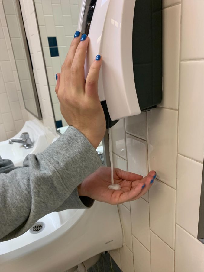 A student uses soap from the dispenser Dec. 8. Soap had not been replaced since the middle of September when repeated vandalism occurred. 