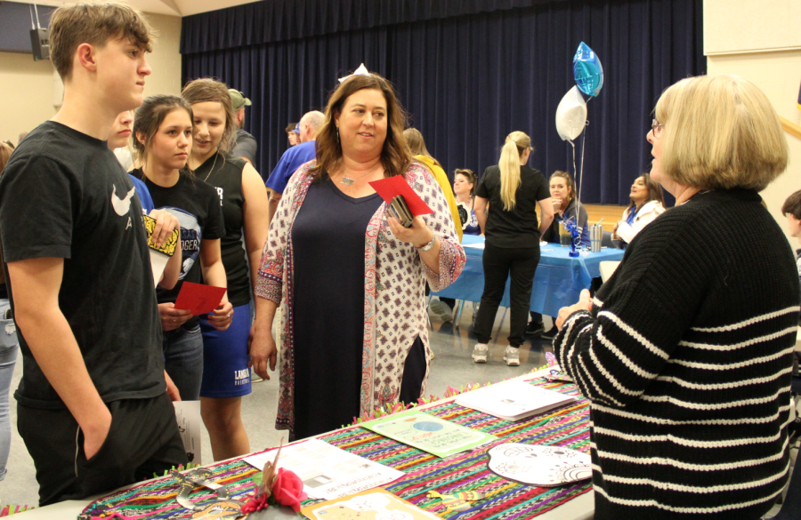 Eighth graders and parents stop by Spanish teacher Kathy Browns table at the activity night to learn about Spanish classes. 