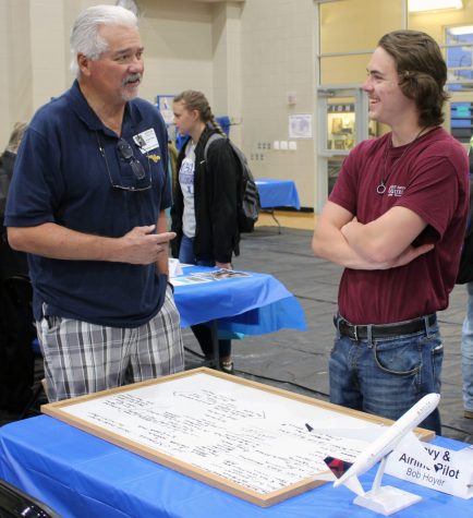 Junior Ethan Gillespie speaks to pilot Bob Hoyer during the Aviation Careers Day March 29.