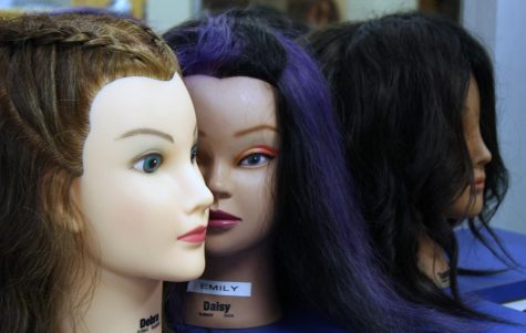 A mannequin displays purple hair in the cosmetology classroom. 