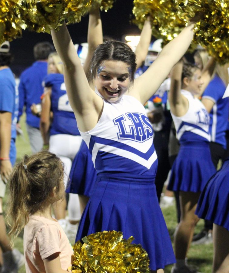 Cheer captain Bella Lindsey cheers with former assistant principal Donna LeJeunes daughter on the sidelines of the Homecoming Game Sept. 23.