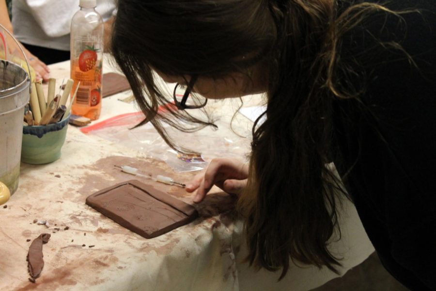Sophomore Ashlie Schmille carves an image in ceramics class.