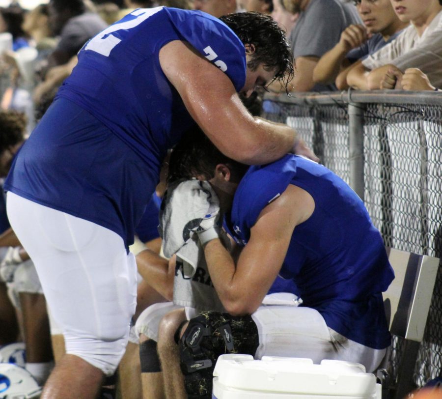 Senior Shea Robinson comforts another player who is upset that they are losing the Homecoming game Sept. 23.