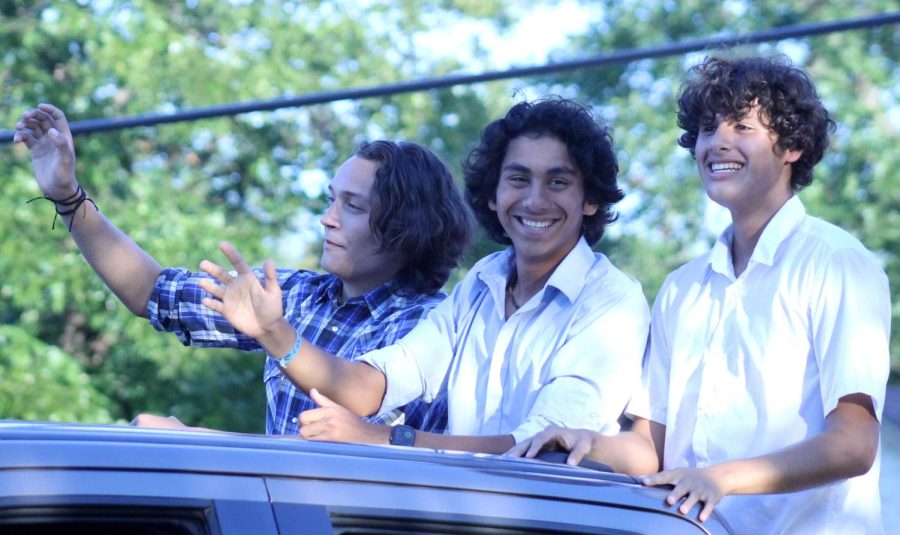 Homecoming king nominees Luke Coonrod, James Vasquez, and JT Saucedo wave to bystanders from their float at the Homecoming parade Sept. 21.