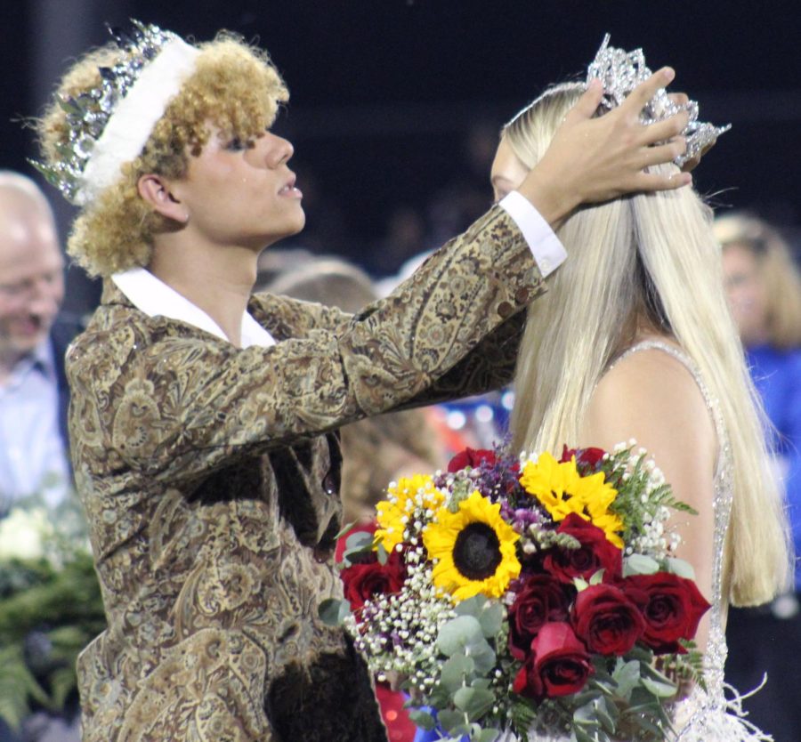 Norton adjusts Roedlers crown before the two take pictures on the football field during halftime Sept. 23.