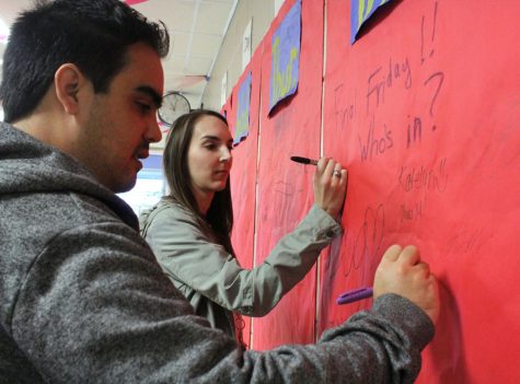 English teachers Nathaniel and Alison Brayton sign the Pledge Wall promising to remain sober Oct. 28.
