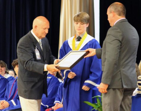 Senior Ben Stone receives the solutatorian award from Principal Joey McQueen and Assistant Principal Paul Weinheimer April 26. 
