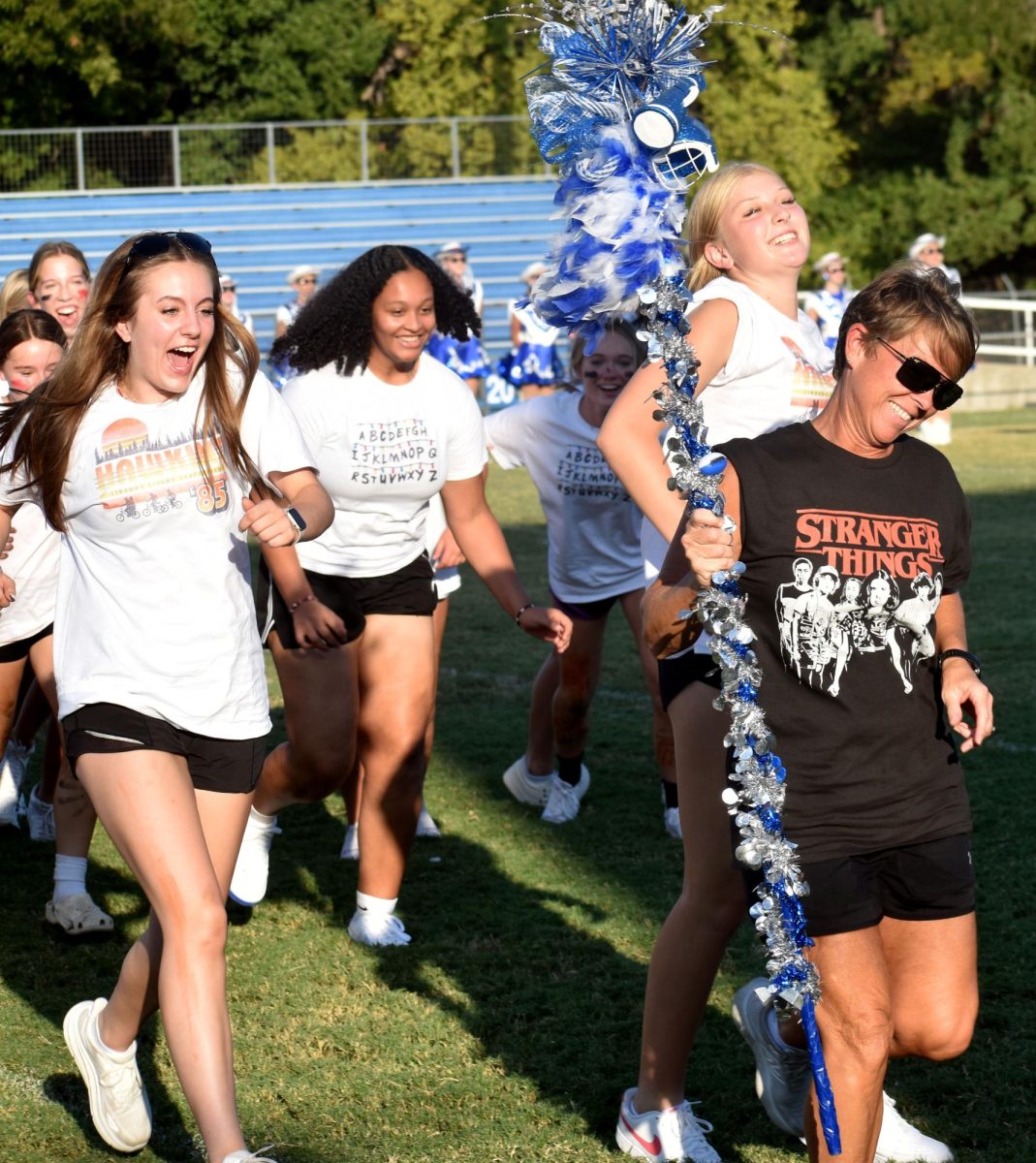 Head volleyball coach Christy Wiley celebrates receiving the First Place HoCo Parade Float Spirit Stick with the volleyball team Sept. 6. 