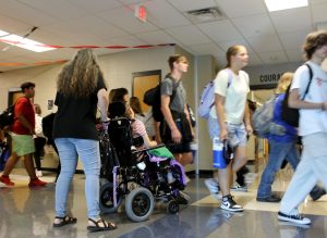 Life Academics teacher Rebecca Veroneau assists a student on their way to second period. 