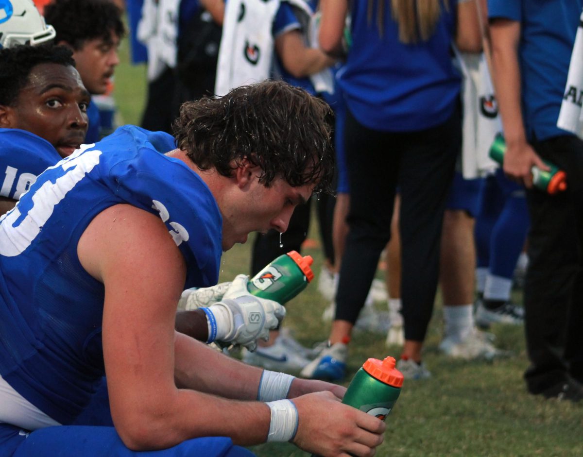 Junior Levi Guthrie uses water to cool off during the Homecoming game Sept. 8.