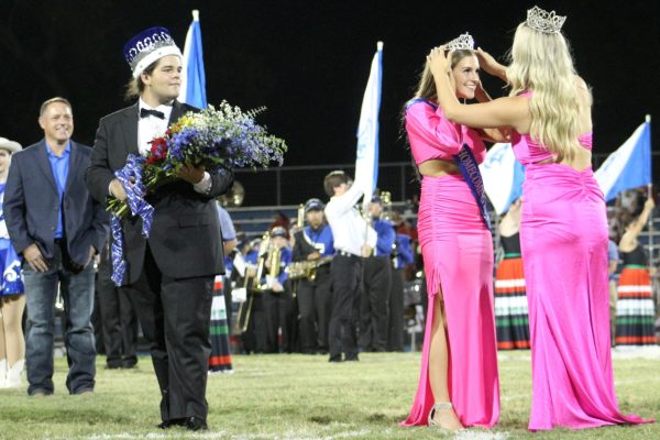 Former Homecoming queen Madison Roedler crowns senior Kenzie Roberts at halftime Sept. 8.Homecoming king Dylan Duvall holds flowers for Kenzie.