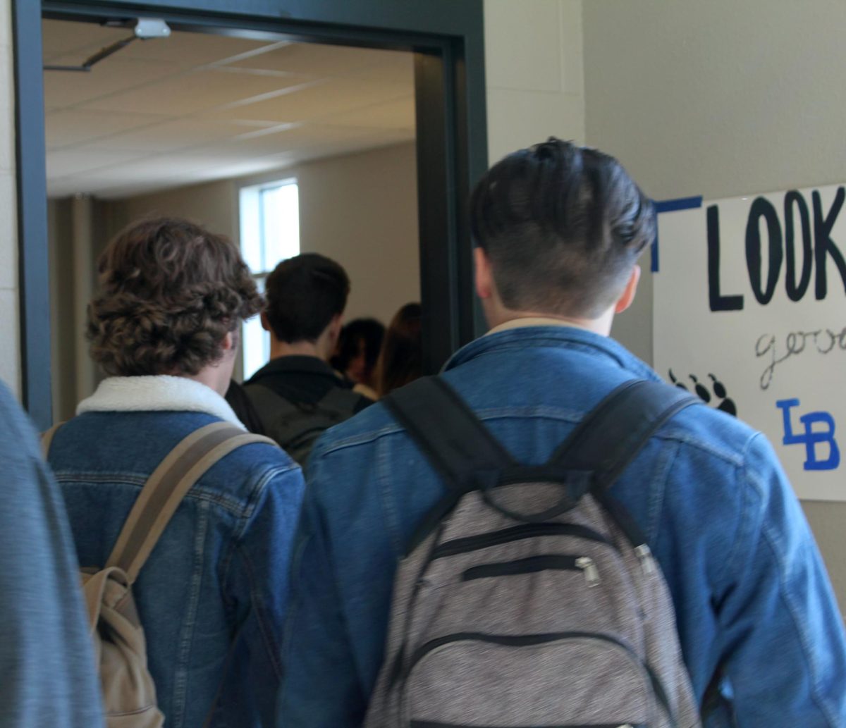 Students make their way through a singular door on their way to fourth period. 