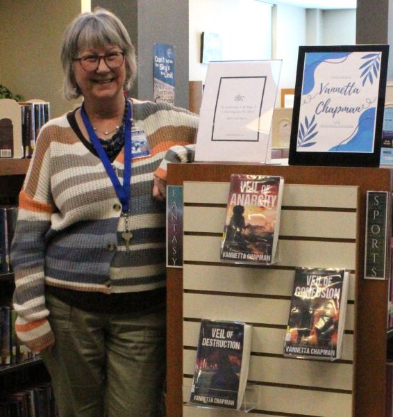 English 2 teacher Vannetta Chapman stands with her Alpine series on display in the library.
