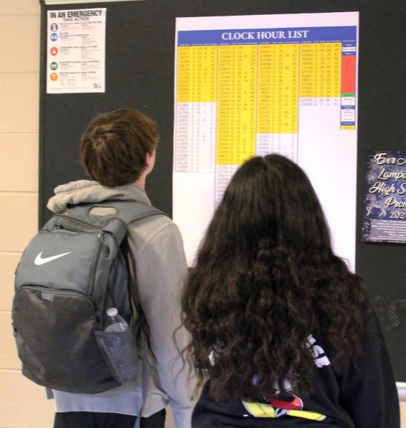 Students check the clock hours list in the hall between classes April 23.