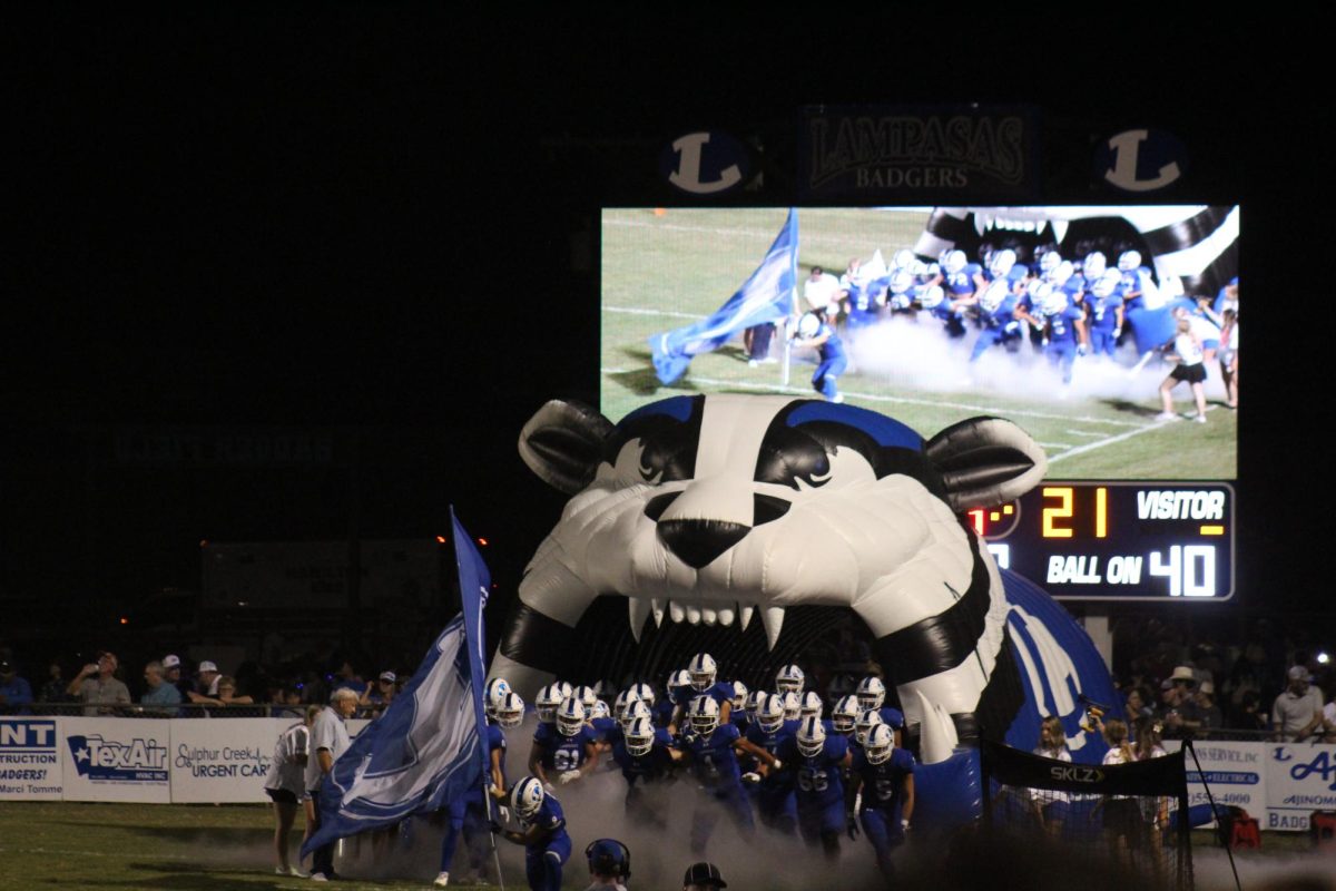 Varsity football players run out of Badger tunnel Aug. 30.