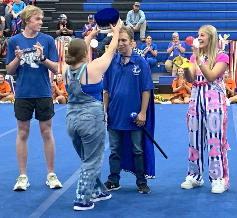 Student council member, senior Chloe Cowdrey crowns senior Jimmy Mcanally as Homecoming King at pep rally Sept. 20. 