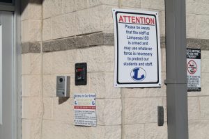 Sign at the main entrance states that some teachers are armed.