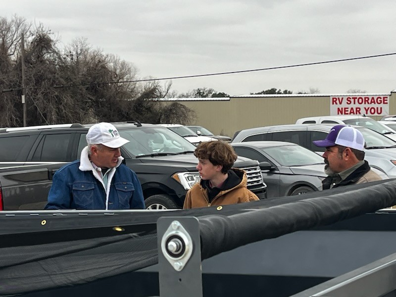 Freshman Kord Bumpus speaks with judges about his hydraulic dump trailer. Bumpus won reserve grand champion.