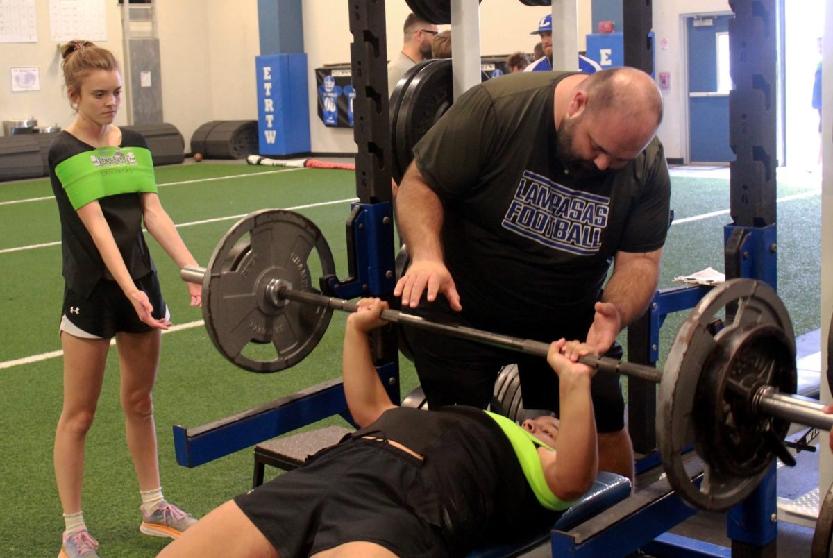 Senior Arianna Bermudez practices bench press alongside senior Hialey Palmer and girls powerlifting coach Tyler Cleavinger during after school practice Feb. 5. 

