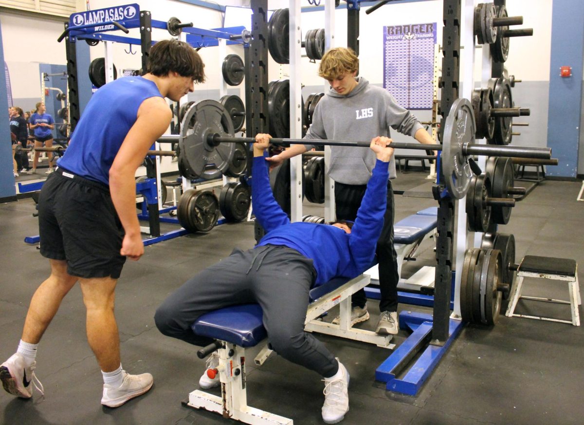 Freshman Luke Lambert spots freshman Rylan Chapa while he bench presses during practice Feb. 10.