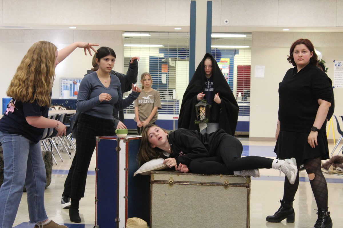 Middle school students rehearse scene in middle school cafeteria.