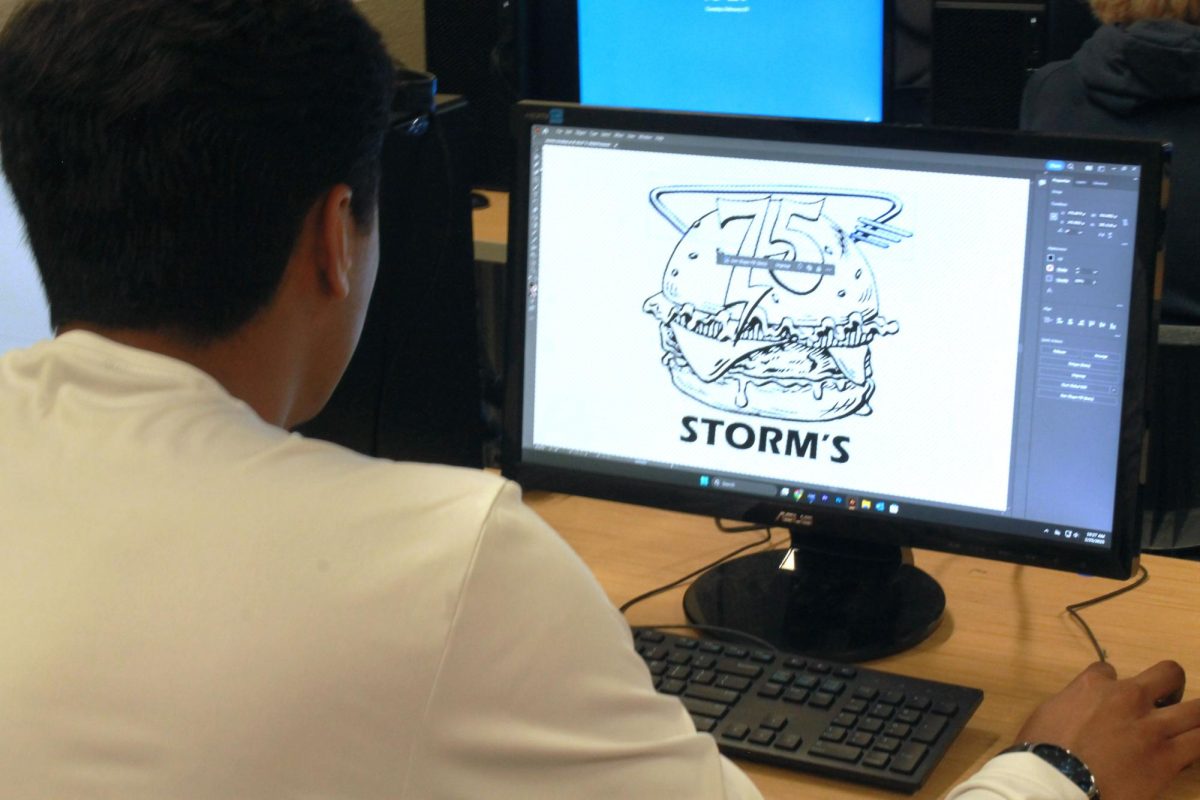 A student works on a draft of the new logo.