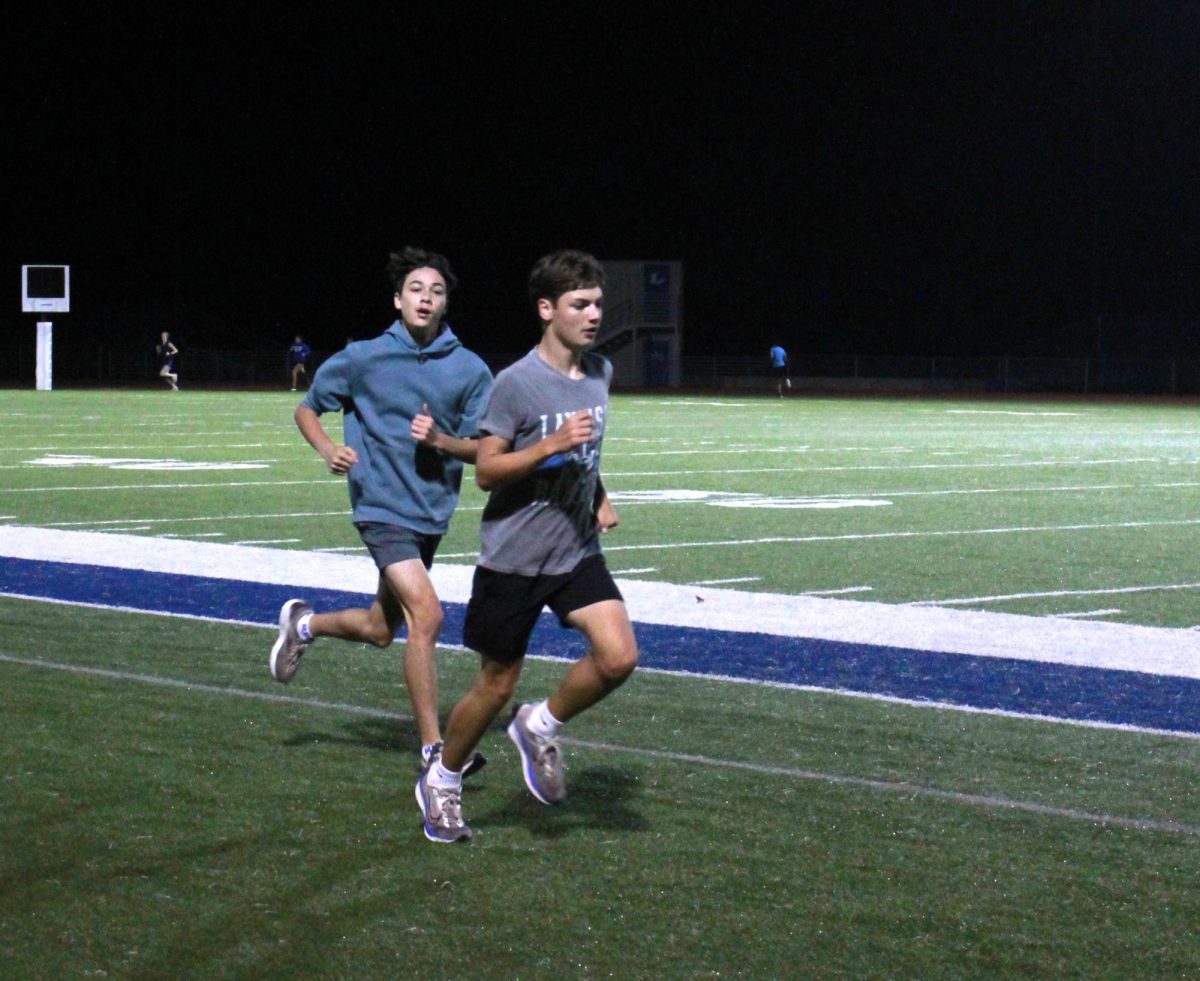 Freshman Elijah Harbin runs with cross country teammates before school  Sept. 26.
