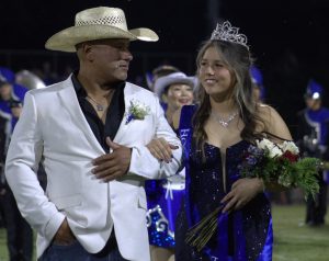 Escorted by her father Robert Resa, senior Jacie Resa celebrates winning homecoming queen during halftime Sept. 26.