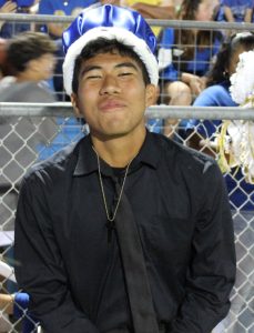 Senior Juan Rodriguez waits on the sidelines during halftime for homecoming queen to be announced.
