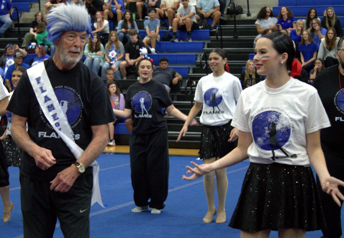 English teacher and coach Bob Davis dances with freshman Tinsley Leffler at the pep rally Sept. 26.