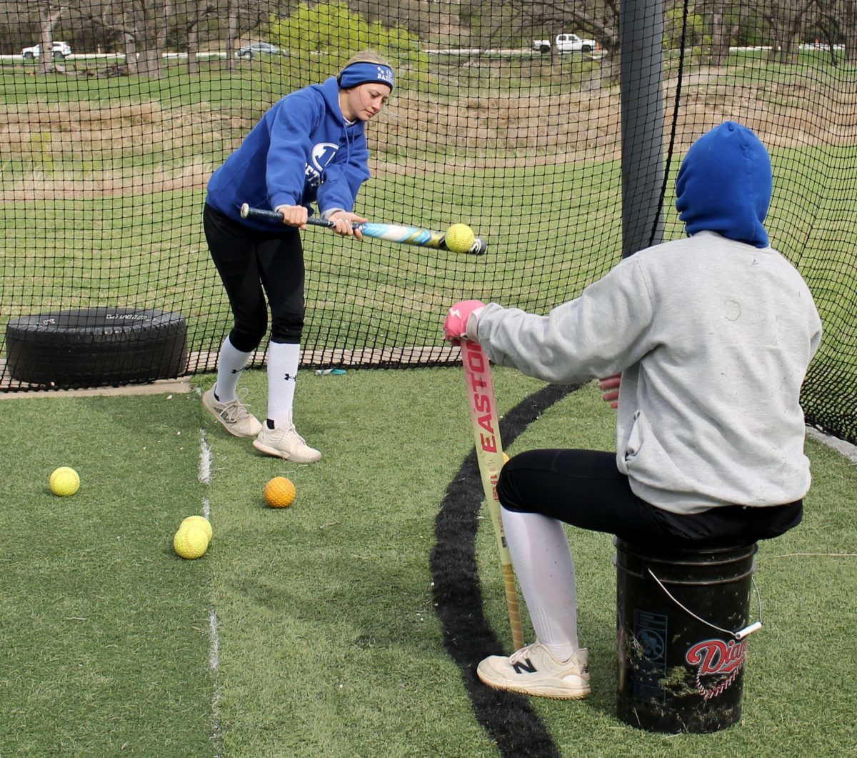 Senior Sagen Plouff practices her bunt in the batting cages during practice March 16. 