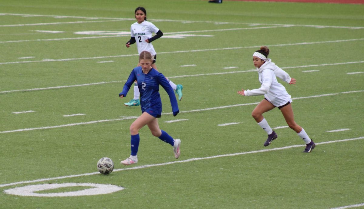 Junior Brylie Centunzi-Sanchez dribbles by 2 Taylor players at game March 16.